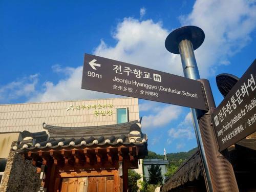 a street sign on a pole in front of a building at Hyanggyo-gil, Seonwooga in Jeonju