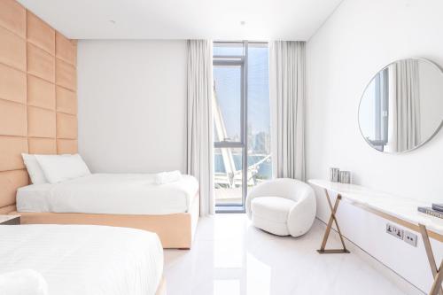 a hotel room with two beds and a mirror at Spectacular 3 BR condo with maids room facing the Dubai Eye in Dubai