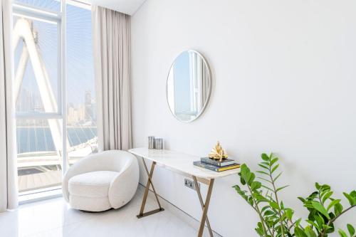 a white office with a white chair and a mirror at Spectacular 3 BR condo with maids room facing the Dubai Eye in Dubai