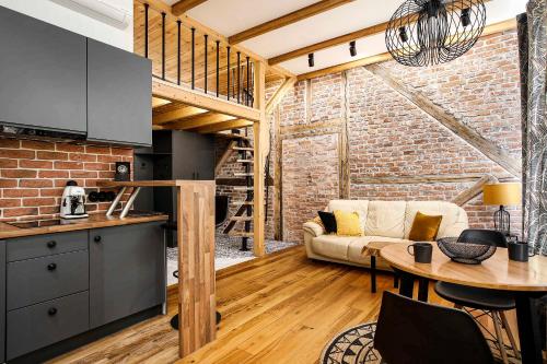 a kitchen and living room with a brick wall at Charming Studio with Air Conditioning, Old Town & Kazimierz in Krakow