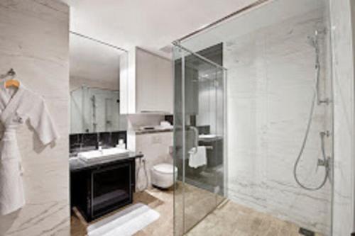 uma casa de banho com uma cabina de duche em vidro e um WC. em The Platinum KLCC By Sky Pool em Kuala Lumpur