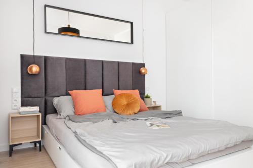 1 dormitorio con 1 cama grande con almohadas de color naranja en Apartamenty Tespis - Sokolska 30 Towers en Katowice