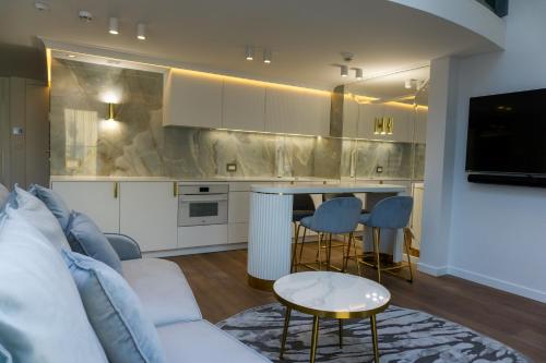 a living room with a white couch and a kitchen at Monte 27 Lux Apartments in Sopot