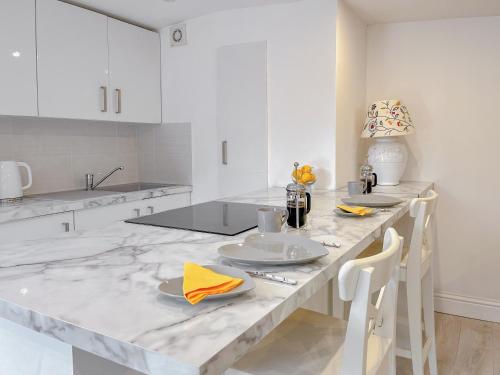 a white kitchen with a marble counter top and white cabinets at The Haven Lodge in Clifton