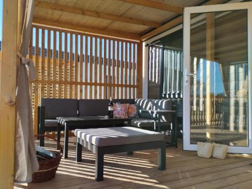 - une terrasse couverte avec un banc et des chaises dans l'établissement Mobile Home Katja, à Banjole