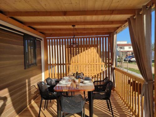 una terraza de madera con mesa y sillas. en Mobile Home Katja en Banjole