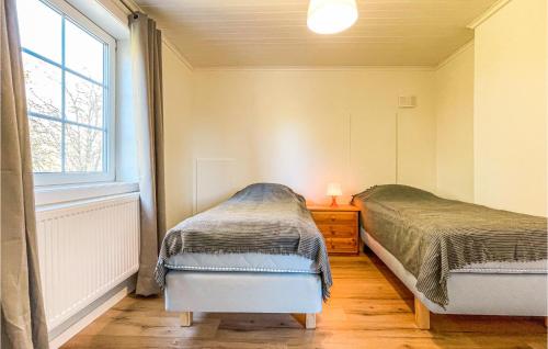 two beds in a bedroom with a window at Awesome Home In rjng With Wifi in Årjäng