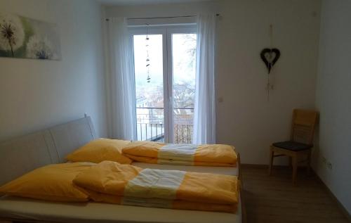 two beds in a room with a window at Ferienwohnung Taubertraum in Weikersheim