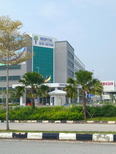 a hospital with palm trees in front of a building at Eusof Homestay in Ipoh