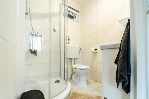 a bathroom with a toilet and a shower at Körösvölgyi Apartmanházak 