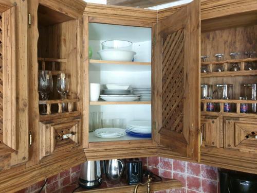 a wooden cabinet with plates and dishes in it at Deluxe Apartments in the city center with Balcony in Pärnu