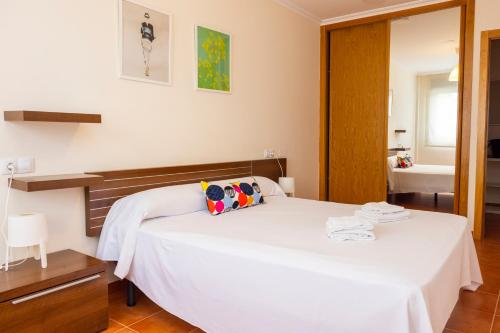 a bedroom with a white bed and a bathroom at Apartagal-Urb. Traiñeira in O Vicedo