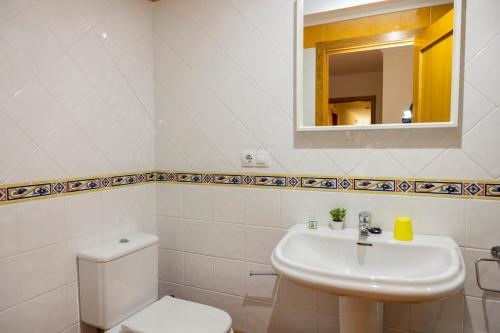 a white bathroom with a toilet and a sink at Apartagal-Urb. Traiñeira in O Vicedo