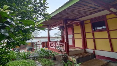 una casa con una fachada roja y amarilla en IEFA Malino Resort en Malino