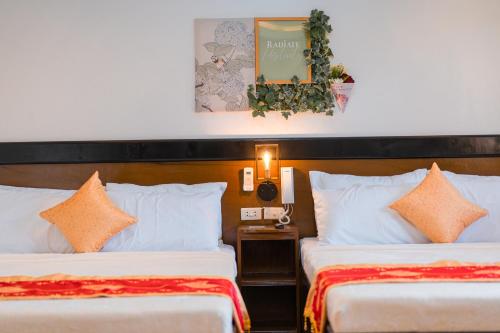 a hotel room with two beds and a mirror at Island Wanderers Inn in Coron