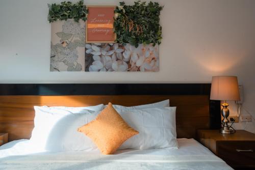 a bed with white pillows and a wooden head board at Island Wanderers Inn in Coron