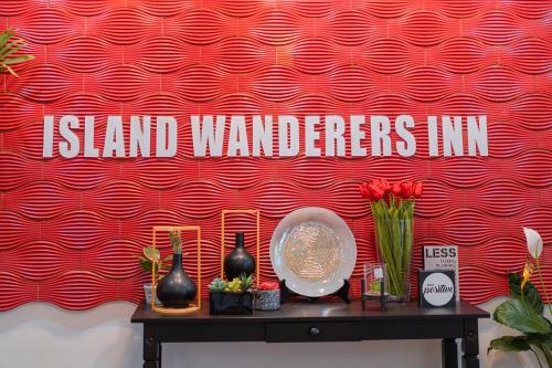 a red wall with a sign that reads island wanderers inn at Island Wanderers Inn in Coron