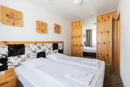a bedroom with two beds and a mirror at VacationClub - Cristal Resort Apartament 314 in Szklarska Poręba