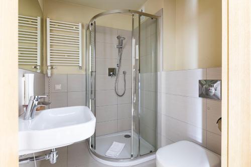 a bathroom with a shower and a sink and a toilet at VacationClub - Cristal Resort Apartament 314 in Szklarska Poręba
