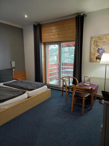 1 dormitorio con cama, mesa y ventana en penzion BABÍ VRCH en Frýdlant nad Ostravicí