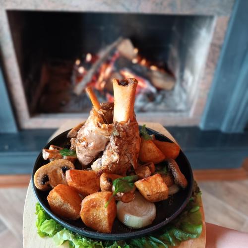 a plate of food in front of a fireplace at Loven dom Berovo in Berovo
