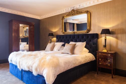 a bedroom with a large bed with a mirror on the wall at Boutique Hotel Opus One in Numansdorp
