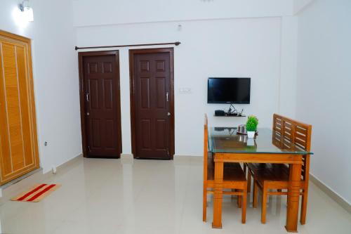 a dining room with a table and a television at The Coorg Heaven in Madikeri
