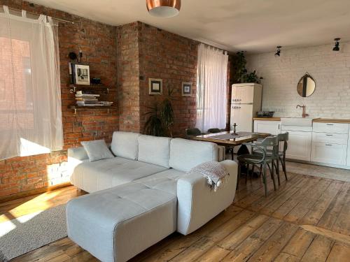 a living room with a couch and a table and a kitchen at Bralu street apartments in Liepāja
