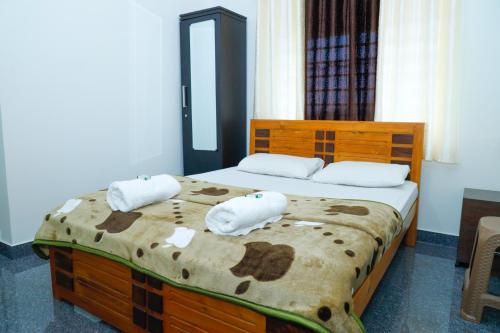 a bedroom with a bed with two towels on it at The Coorg Heaven in Madikeri