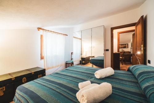 a bedroom with a large bed with two white chairs at Casa Zip in Marciana