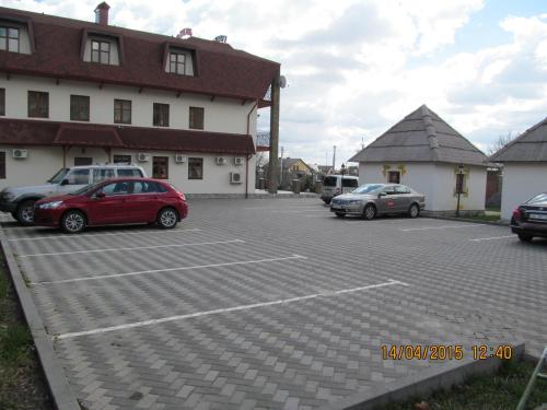a parking lot with cars parked in front of a building at Stara Vezha Hotel in Boryspilʼ