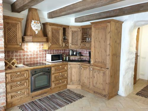 a kitchen with wooden cabinets and a microwave at Deluxe Apartments in the city center with Balcony in Pärnu