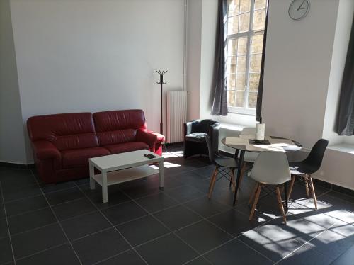 ein Wohnzimmer mit einem roten Sofa und einem Tisch in der Unterkunft O'Couvent - Appartement 87 m2 - 4 chambres - A501 in Salins-les-Bains