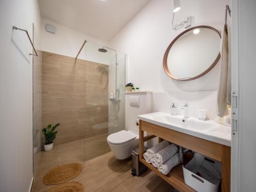 een badkamer met een wastafel, een toilet en een spiegel bij Holiday Home Vallis in Povlja