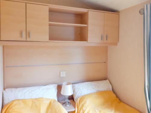 a small bedroom with a bed and cabinets at Doggy Dell in Motcombe