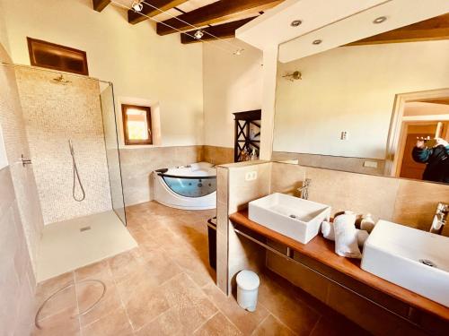 a bathroom with two sinks and a shower and a tub at Finca Son Amoyana Capdepera in Capdepera
