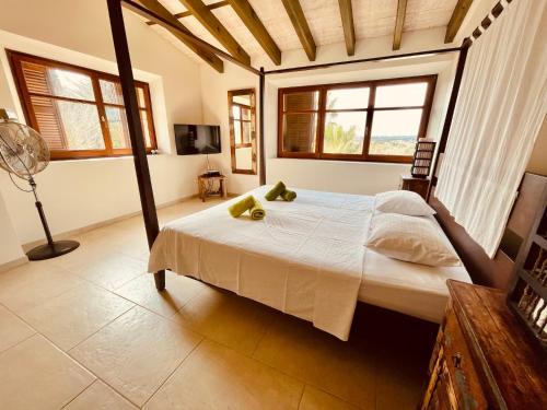 a bedroom with a bed in a room with windows at Finca Son Amoyana Capdepera in Capdepera