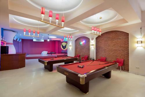 a pool room with two pool tables and red chairs at Granada Luxury Okurcalar in Okurcalar