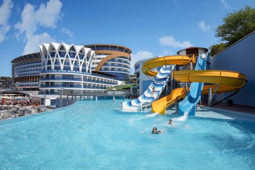 a pool with a water slide on a cruise ship at Granada Luxury Okurcalar in Okurcalar