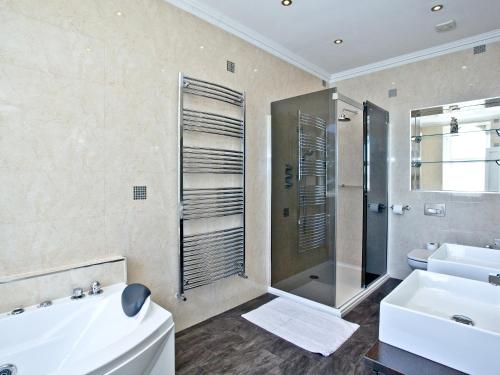 a bathroom with a tub and a sink and a shower at Riviera Mansion, Torquay in Torquay