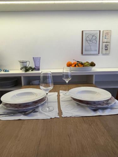 a table with two plates and two wine glasses at House called Happiness in Jelsa