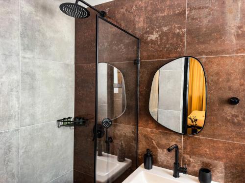 a bathroom with a sink and a mirror on the wall at Levinski Market Hotel in Tel Aviv