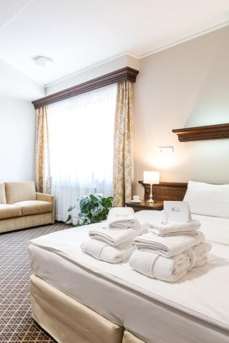 a hotel room with a bed with white towels on it at Hotel Crocus in Zakopane