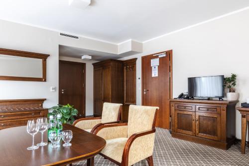 a living room with a table and chairs and a television at Hotel Crocus in Zakopane
