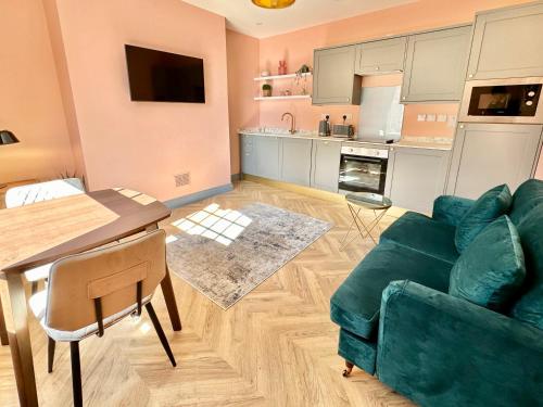 a living room with a green couch and a kitchen at The Bradley in Market Weighton