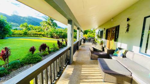 een balkon met banken en uitzicht op een golfbaan bij Inave Oasis 3 Bedroom Villa "Your home away from Home" in Arorangi