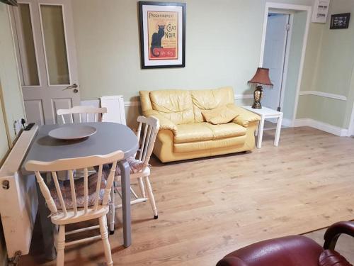 sala de estar con mesa, sillas y sofá en Coastal Cottage en Dromore West