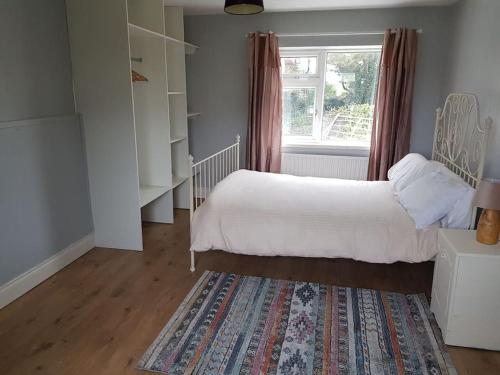 a bedroom with a bed and a window and a rug at Coastal Cottage in Dromore West