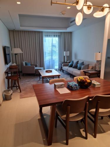 a living room with a table and a couch at Two Bedroom-The Address Beach Resort Fujairah in Sharm