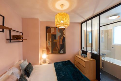 1 dormitorio con cama y lámpara de araña en Halcyon, en París